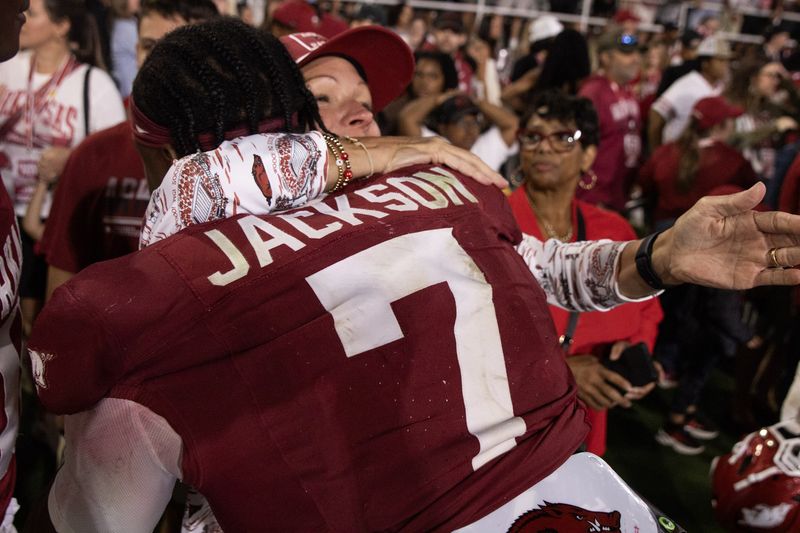 Razorback number 7 hugs a woman on the field after a game