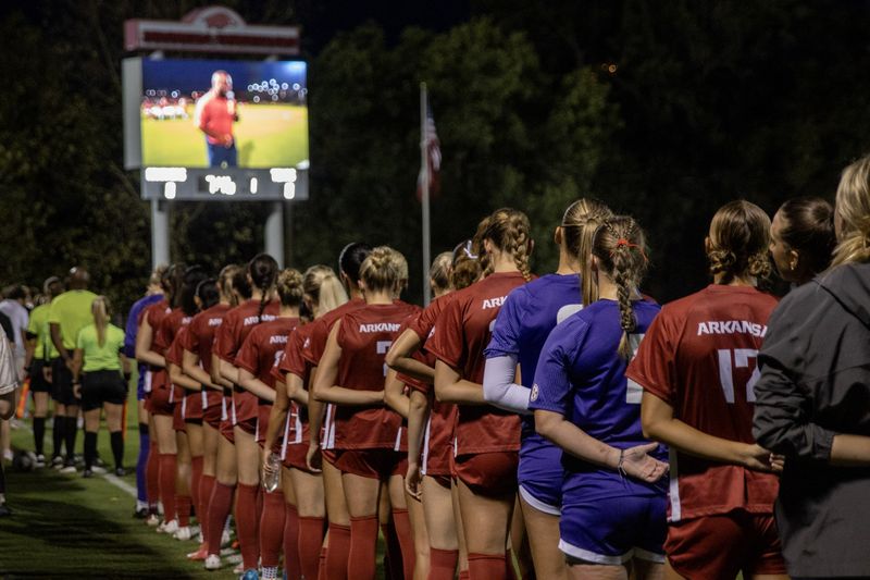 Razorback soccer players line up arm in arm for the anthem