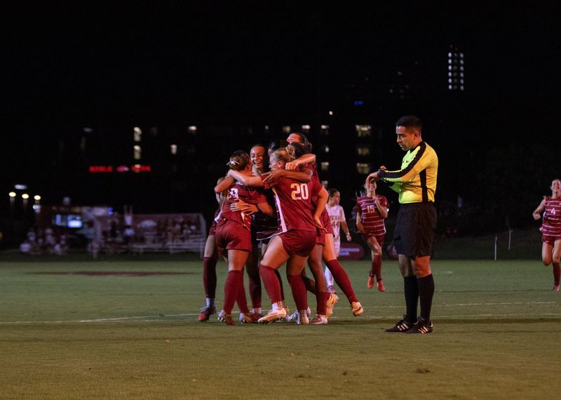 Razorback soccer team celebrates a goal at night