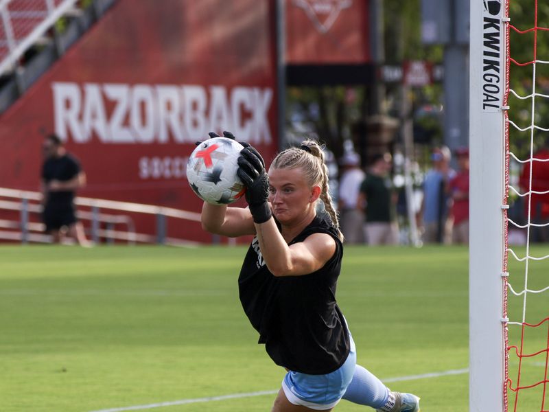 Razorback soccer goalkeeper catches the ball at the post