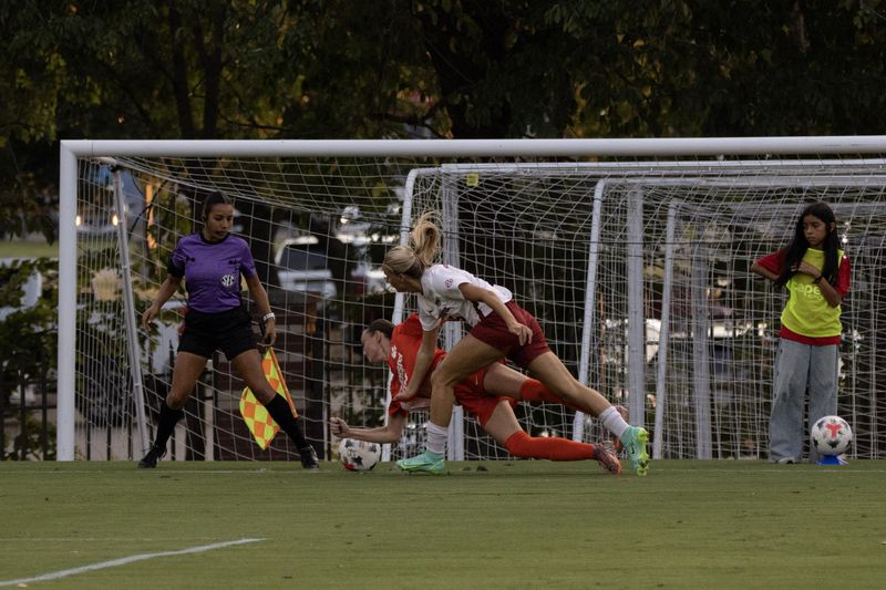 Razorback soccer players slide for the ball near the goal