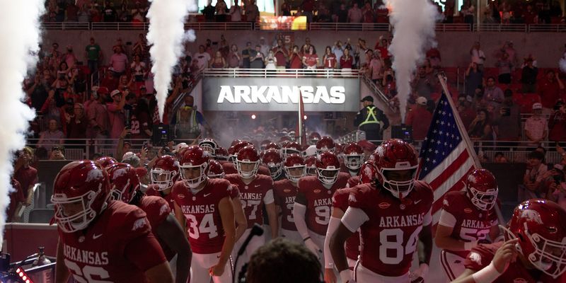 Razorback football team gathers under the Arkansas sign as pregame flames go up