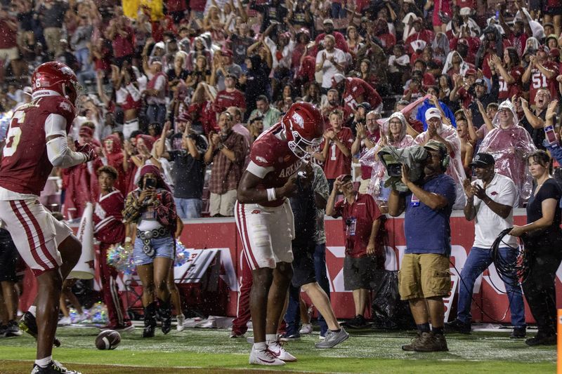 Razorback players celebrate in the end zone in front of the student section